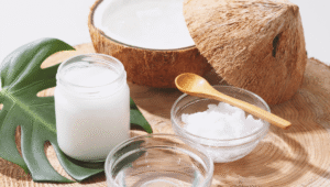 Natural skincare ingredients including coconut oil and cream on a wooden surface.