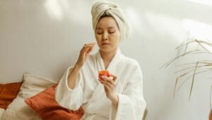 Woman applying natural face cream at home as part of her skin tightening homemade remedies routine.