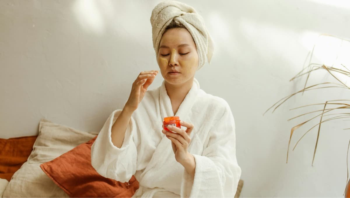 Woman applying natural face cream at home as part of her skin tightening homemade remedies routine.